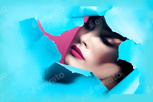 Preview: Young beautiful woman with clean perfect skin through gap in cardboard