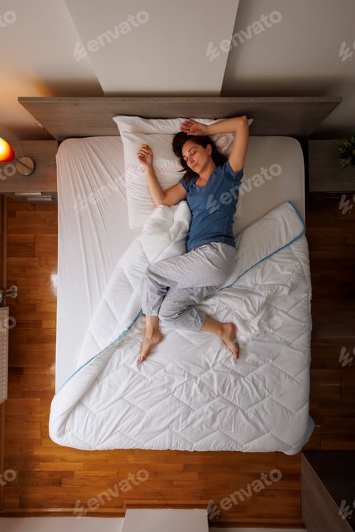 Preview: Top view of woman sleeping in bed