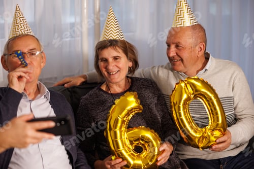 Preview: Senior friends having fun taking selfies at birthday party