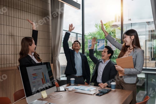 Preview: Business team celebrating success achieving goals with high fives