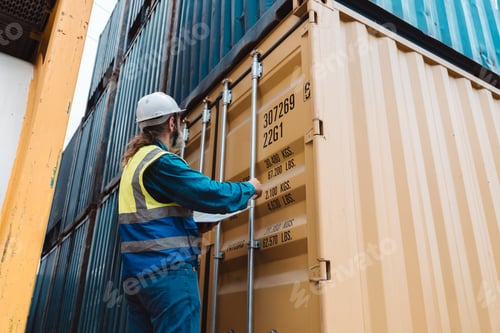 Preview: Senior industrial safety inspector pointing at hazardous caution label on cargo container. Logistics