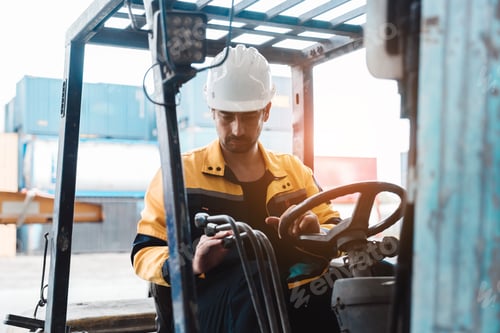 Preview: Logistics worker operating forklift truck at cargo yard. Caucasian engineer driving and controlling