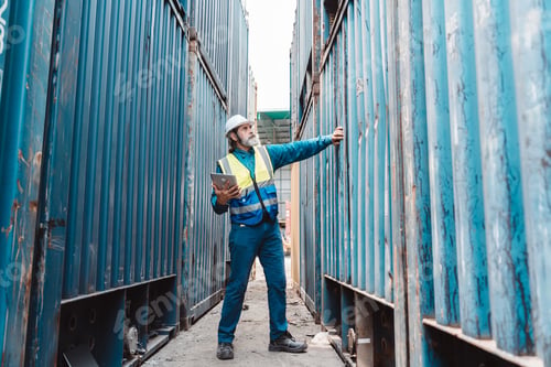 Preview: Senior logistics inspector using walkie-talkie and tablet at port. Industrial manager checking cargo