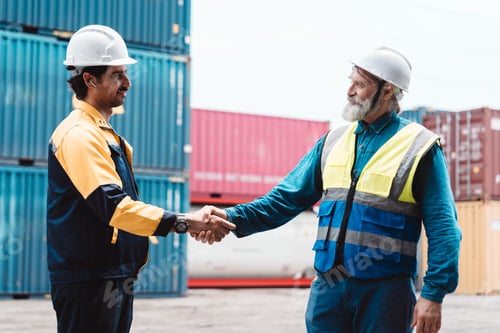 Preview: Industrial engineers shaking hands for partnership at shipping yard. Caucasian workers handshake for