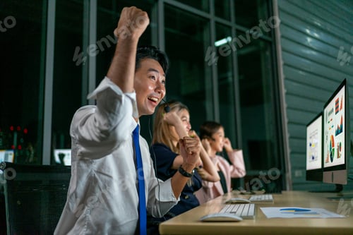 Preview: Three coworkers celebrating success while wearing headsets at night