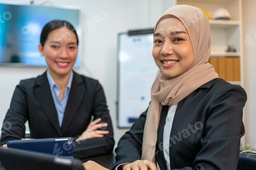Preview: Two Businesswomen Smiling and Looking at Camera in Office