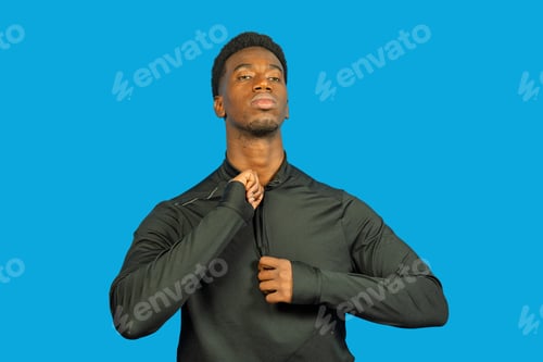 Preview: Young black man zipping up athletic shirt