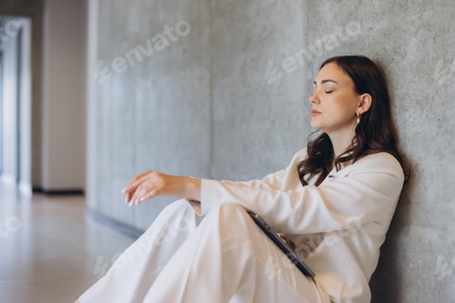 Preview: Young woman feeling tired and exhausted, experiencing burnout or stress at work, sitting on office