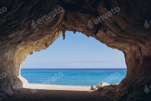 Preview: Cala Luna beach cave entrance on Sardinia island, looking out to turquoise Mediterranean sea and blu