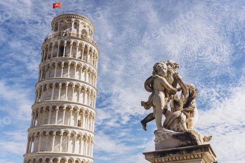 Preview: Famous Leaning Tower of Pisa in Tuscany, Italy, with a marble cupid statue foreground, under a brigh