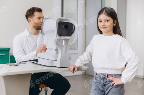Preview: Patient and eye doctor in a modern clinic. Young girl smiling during an eye exam, ensuring healthy v