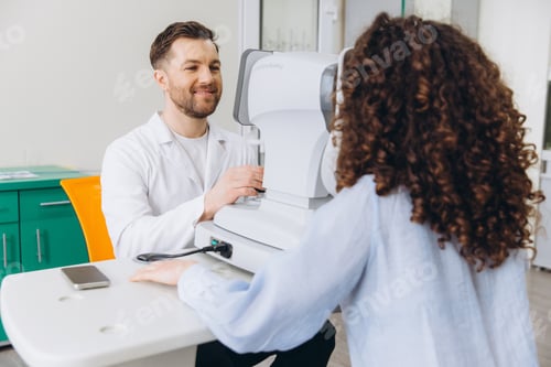 Preview: Optometrist conducting a vision test for a female patient, using an autorefractor for eye care and e