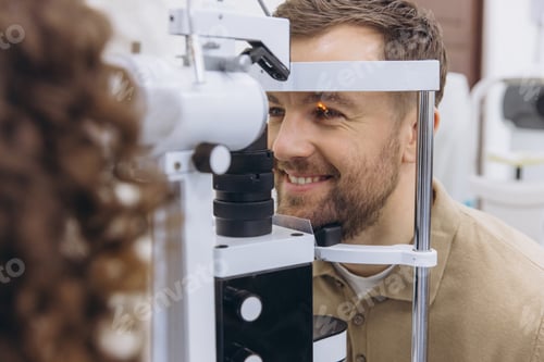 Preview: Man having an ophthalmologist examining his eyes with a slit lamp for vision health and medical care