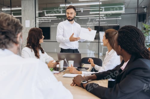 Preview: Manager presenting growth charts to colleagues, discussing strategy in a modern workplace