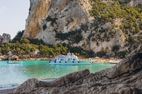 Preview: Tourists arriving at Cala Luna beach in the Gulf of Orosei, Sardinia, Italy, with clear turquoise se