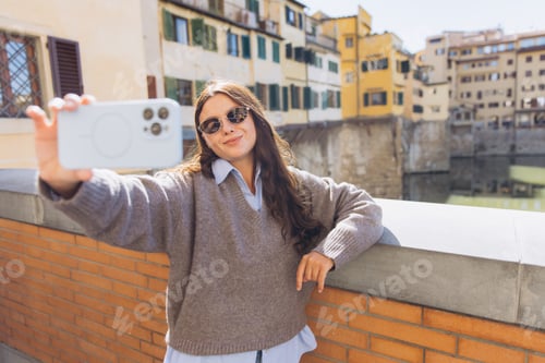 Preview: Young woman enjoying European vacation, taking a selfie with smartphone on Ponte Vecchio, Florence,