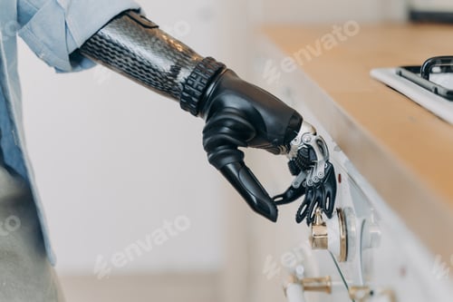 Preview: Electronic cyber hand of disabled person is switching a stove. Sensor in fingers and wrist joint.