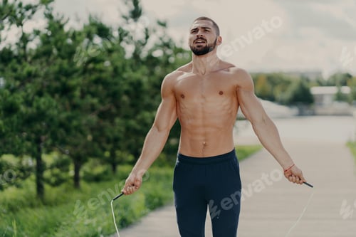 Preview: Muscular Shirtless Man Skipping Jump Rope During Intense Cardio Workout Session on Outdoor Path With