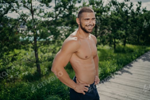 Preview: Active healthy lifestyle concept. Cheerful sporty man works out in nature, enjoys athlete exercising