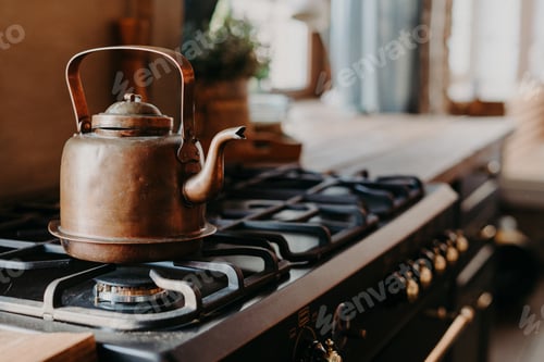 Preview: Vintage copper kettle heats on gas stove in rustic kitchen interior