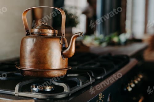 Preview: Vintage copper kettle heats on gas stove in rustic home kitchen