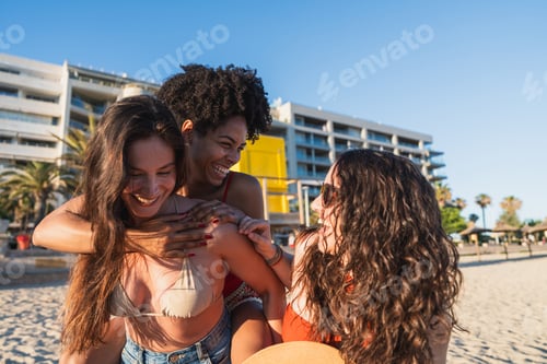 Preview: Diverse friends enjoying piggyback ride laughing on beach