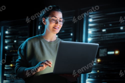 Preview: Confident IT Specialist Working on Laptop in Modern Server Room