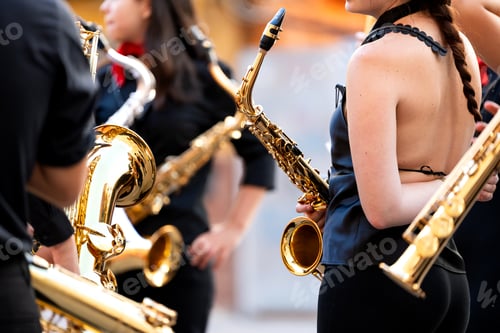 Preview: Musicians performing street concert, holding brass saxophones in spain