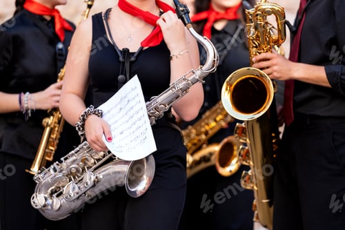 Preview: Young spanish musicians performing street concert with saxophones and sheet music