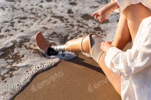 Preview: Person with prosthetic leg enjoying the beach, waves wetting sand and limb