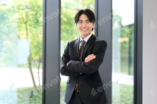 Preview: Asian businessman standing with a smile