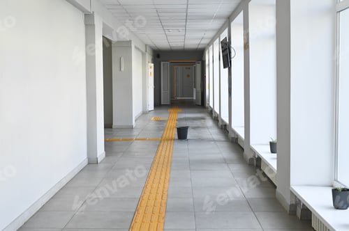 Preview: Bright school corridor with yellow tactile path on tiled floor,