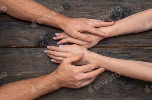 Preview: Male and female hands touch gently on dark rustic wooden table showing love. Tender palms express ro