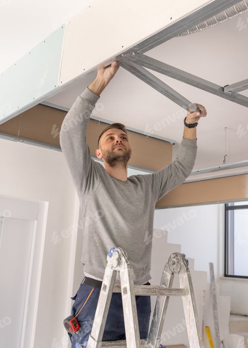 Preview: Construction worker installs metal profile frame for drywall suspended ceiling system in apartment