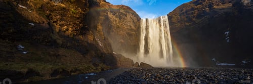Preview: The Skagafoss waterfall, a tall cascade over a sheer cliff, mist and a Double Rainbow in the air.