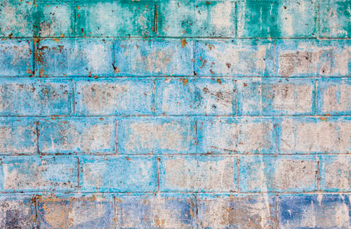 Preview: Aged and textured cinder block wall with fading blue, green, and purple paint in Isla Mujeres,backgr