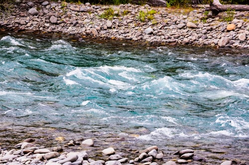 Preview: Clear flowing water of a river running over gravel.