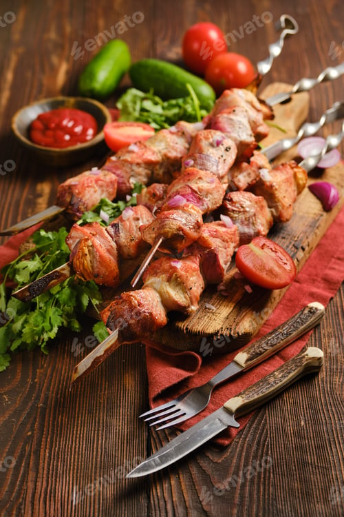 Preview: Delicious shish kebab served with fresh vegetables on a wooden table at a casual dining setting