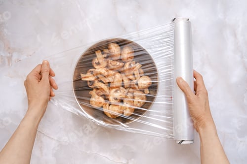Preview: Preparing to store sliced mushrooms with plastic wrap in a kitchen setting