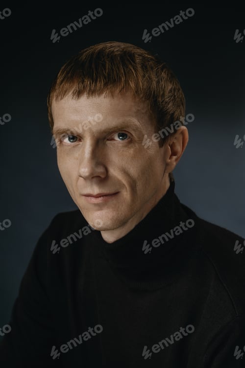 Preview: Portrait of a person with short hair and a black sweater looking at the camera indoors