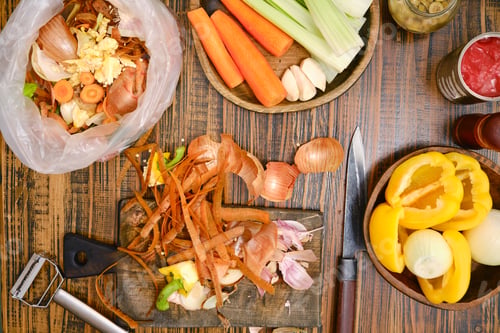Preview: Cooking preparation with vegetables and scraps on a wooden table in a home kitchen setting