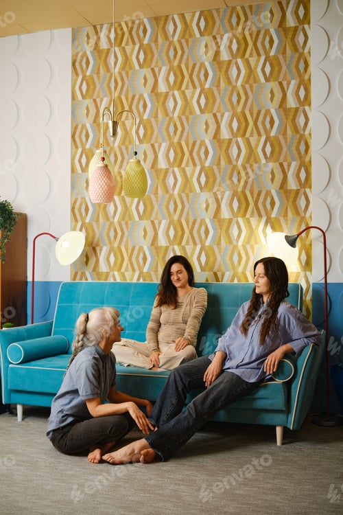 Preview: Three women engage in a conversation in a cozy room with colorful decor and furniture