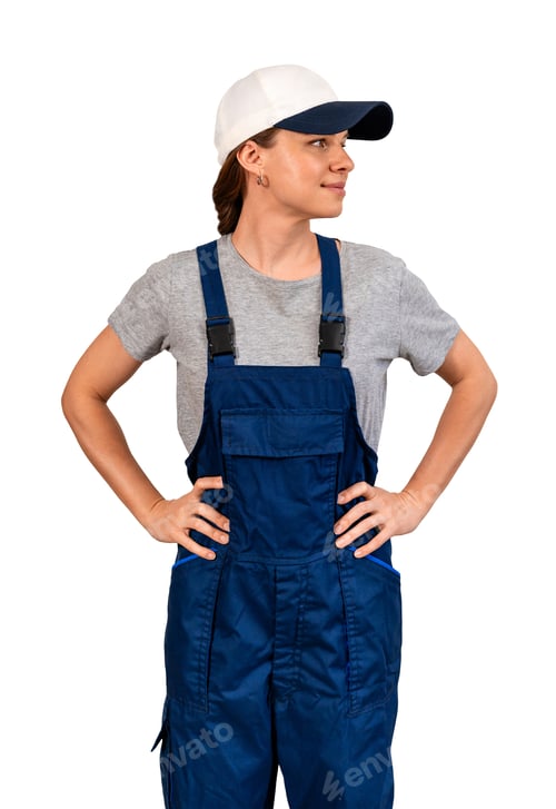 Preview: Adult female blue-collar worker wearing blue bib overalls and cap standing with hands on hips.