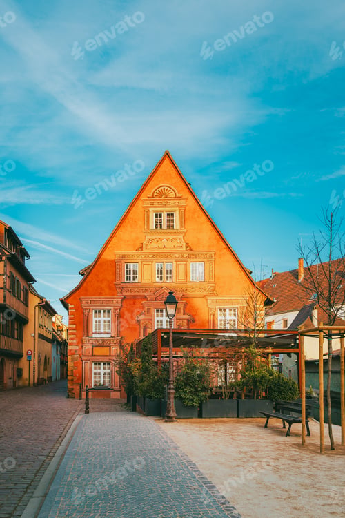 Preview: Colmar half-timbered alley at morning with warm light and open doorway