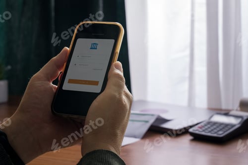 Preview: Adult man logging into mobile banking app on smartphone at home