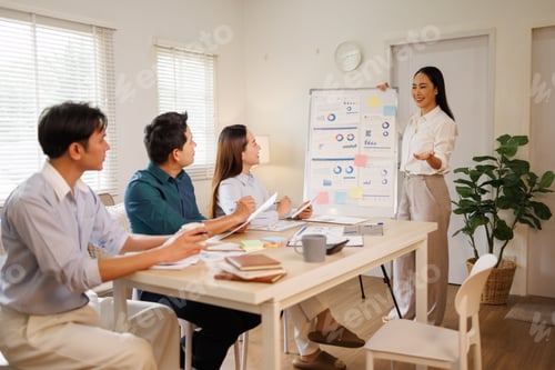 Preview: Asian business team collaborating on presentation during meeting