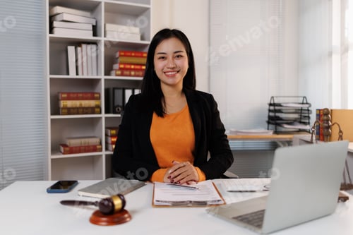 Preview: Young asian female legal professional smiling at desk, representing justice, law, and business exper