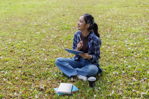 Preview: Young woman studying outdoors with digital tablet