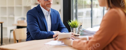 Preview: Businessman having interview with female recruiter in modern office