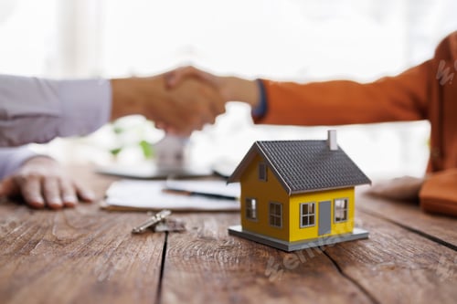 Preview: Real estate agents shaking hands on a house deal